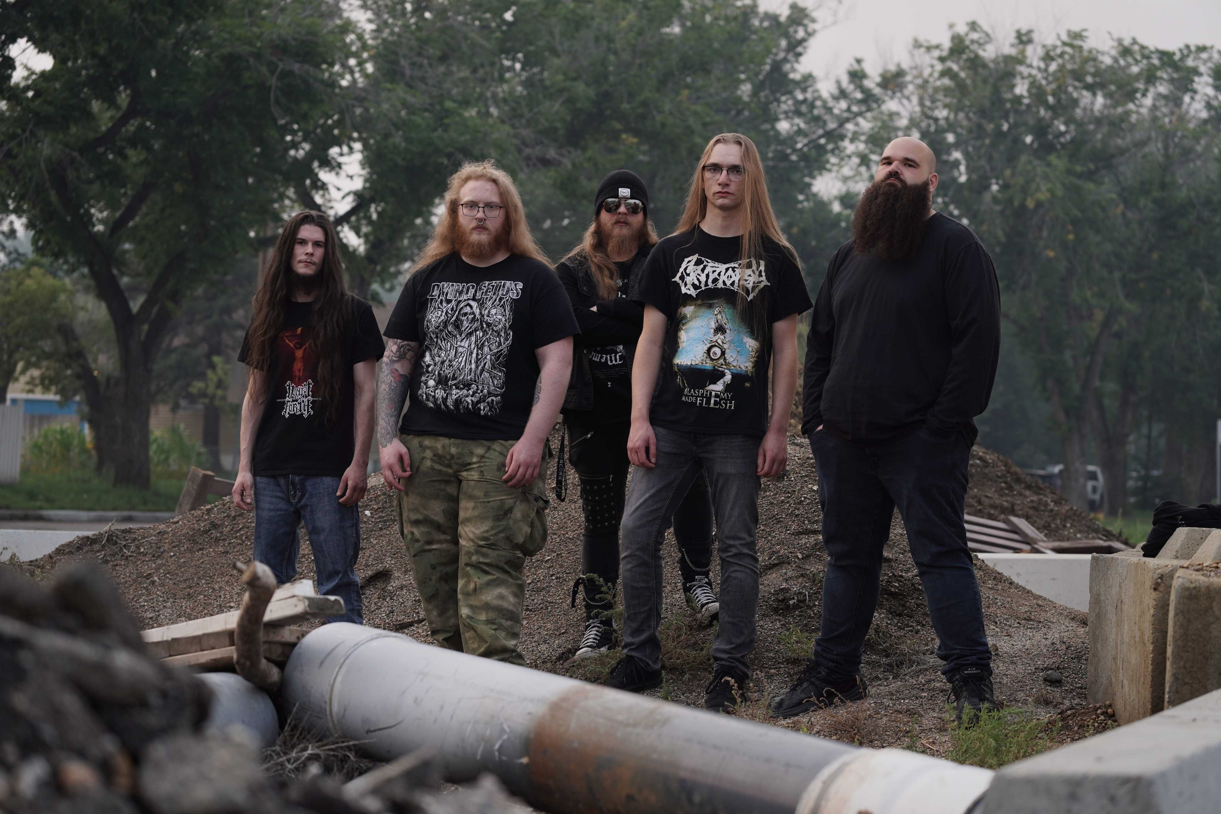 A portrait of the Pythonic band members in a rundown scrap filled area