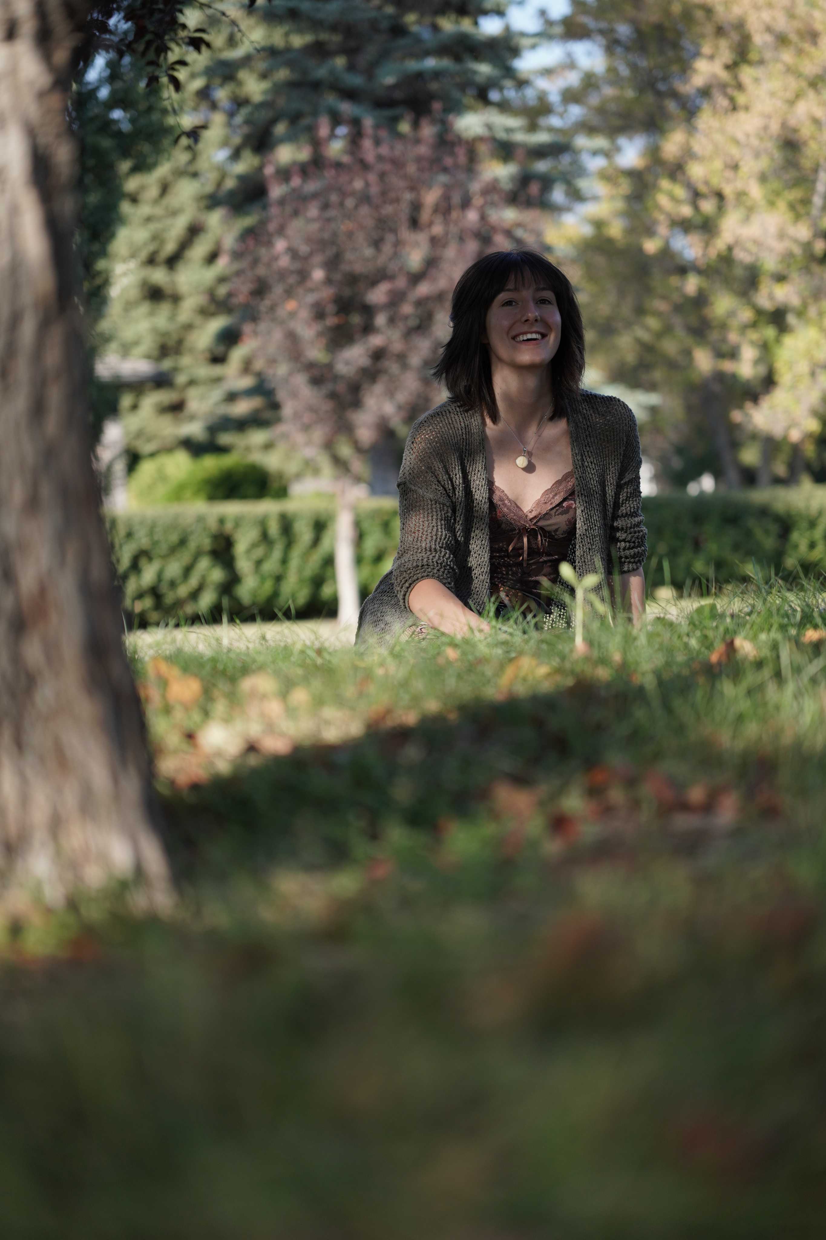 A portrait of woman sitting in a park